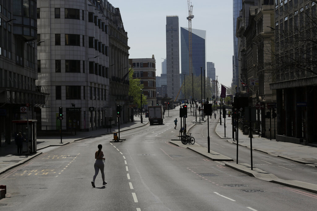 FILE  - In this Wednesday, April 15, 2020 file photo, joggers cross over a quiet New Bridge Street in London, during the lockdown to try and stop the spread of coronavirus. Unemployment across the U.K. has held steady during the coronavirus lockdown as a result of a government salary support scheme, but there are clear signals emerging that job losses will skyrocket over coming months. The Office for National Statistics said Thursday, July 16, 2020 there were 649,000 fewer people, or 2.2%, on payroll in June when compared with March when the lockdown restrictions were imposed.  (AP Photo/Matt Dunham, File)