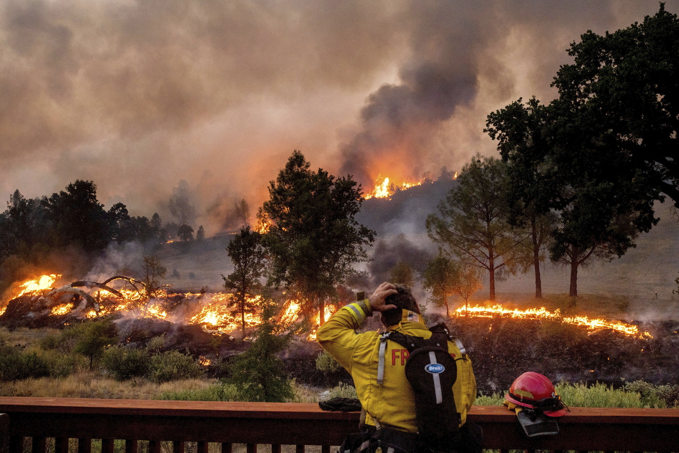 A firefighter rubs his head while watching the LNU Lightning Complex fires spread through the Berryessa Estates neighborhood of unincorporated Napa County, Calif., on Friday, Aug. 21, 2020. The blaze forced thousands to flee and destroyed hundreds of homes and other structures. (AP Photo/Noah Berger)