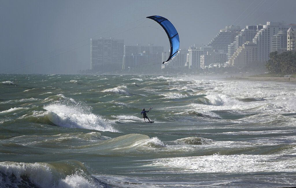 A kite surfer enjoys the wind in Lauderdale, Fla., Monday, Aug. 24, 2020. Tropical Storm Marco began falling apart Monday, easing one threat to the Gulf Coast but setting the stage for the arrival of Laura as a potentially supercharged Category 3 hurricane with winds topping 110 mph (177 kph). (Joe Cavaretta/South Florida Sun-Sentinel via AP)
