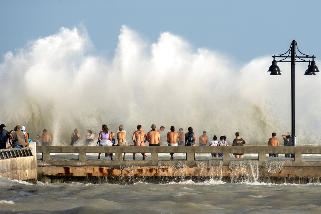 Curious residents of Key West, Fla., flock to the Edward B. Knight Pier Monday, Aug. 24, 2020, to witness the wind and wave action of Hurricane Laura as the storm passes well to the west of the Florida Keys.  (Rob O'Neal/The Key West Citizen via AP)