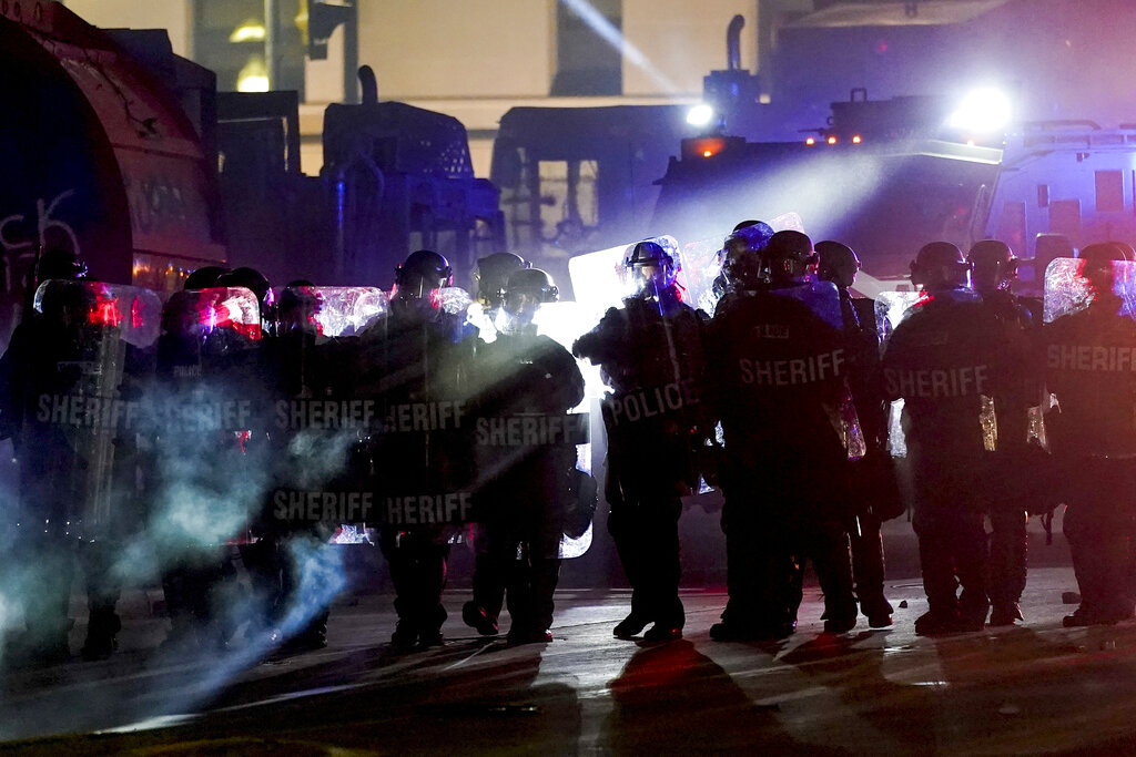 FILE - In this Aug. 25, 2020 file photo, authorities disperse people from a park in Kenosha, Wis. Police in Kenosha have arrested dozens of people since a white office shot a Black man in the back. Activists in the Wisconsin city say police have been aggressive in responding to protests over Jacob Blake's shooting, even as they've tolerated armed militia groups. (AP Photo/Morry Gash, File)