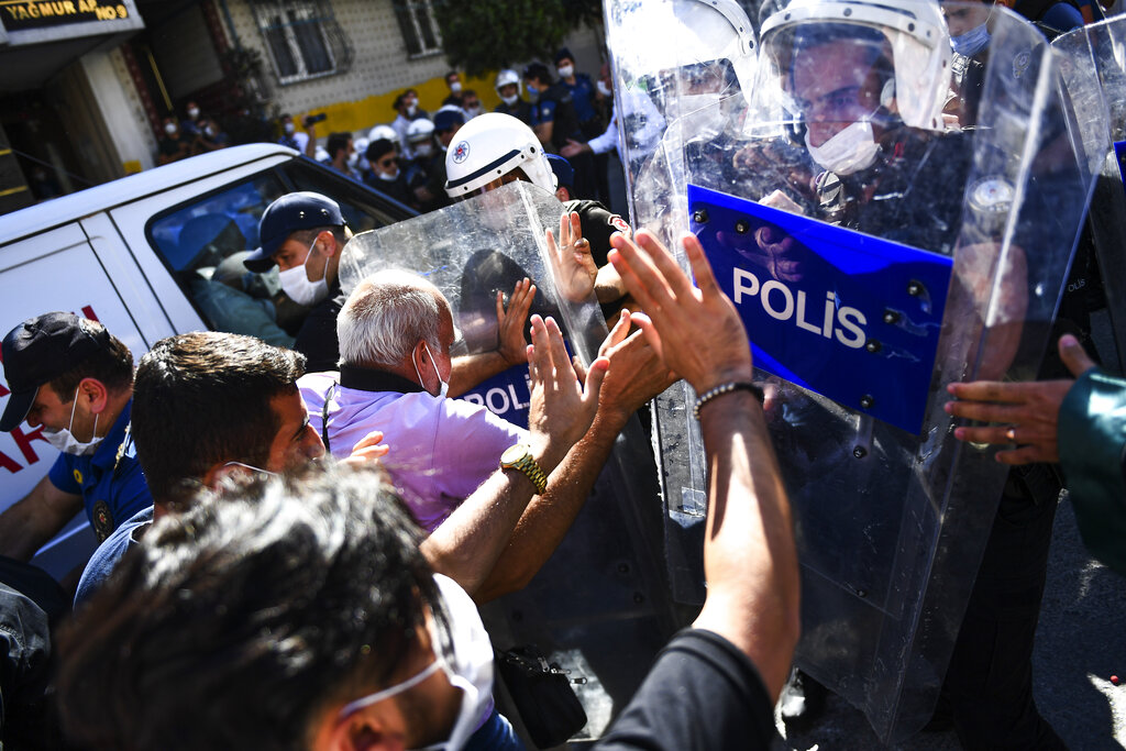 People clash with police during the funeral of Ebru Timtik, a human rights lawyer who died during hunger strike in a Turkish prison to demand a fair trial for herself and colleagues, in Istanbul, Friday, Aug. 28, 2020. Timtik, 42, died in an Istanbul hospital late Thursday, the Progressive Lawyers' Association said. She had been fasting for 238 days.(AP Photo)