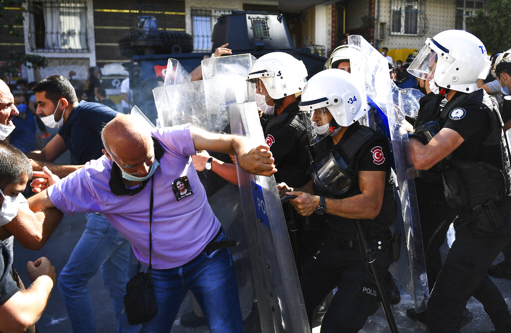 People clash with police during the funeral of Ebru Timtik, a human rights lawyer who died during a hunger strike in a Turkish prison to demand a fair trial for herself and colleagues, in Istanbul, Friday, Aug. 28, 2020. Timtik, 42, died in an Istanbul hospital late Thursday, the Progressive Lawyers' Association said. She had been fasting for 238 days. (AP Photo)