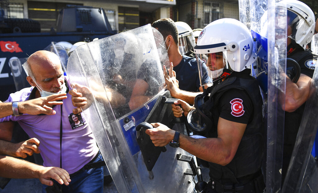 People clash with police during the funeral of Ebru Timtik, a human rights lawyer who died during a hunger strike in a Turkish prison to demand a fair trial for herself and colleagues, in Istanbul, Friday, Aug. 28, 2020. Timtik, 42, died in an Istanbul hospital late Thursday, the Progressive Lawyers' Association said. She had been fasting for 238 days.(AP Photo)