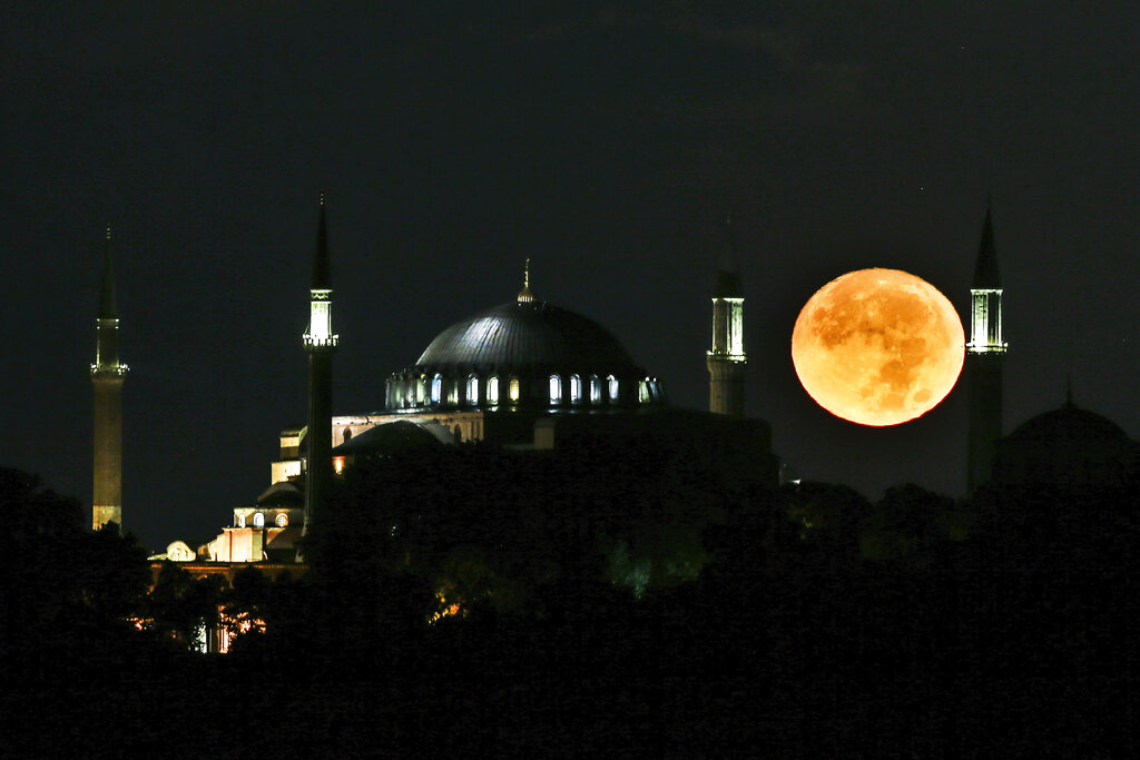 The full moon rises behind the Byzantine-era Hagia Sophia in the historic Sultanahmet district of Istanbul, early Tuesday, Sept. 1, 2020. Worshipers held the first Muslim prayers in 86 years inside the Istanbul landmark that served as one of Christendom's most significant cathedrals, a mosque and a museum before its conversion back into a Muslim place of worship on July 24, 2020. The conversion of the edifice, has led to an international outcry. (AP Photo/Emrah Gurel)