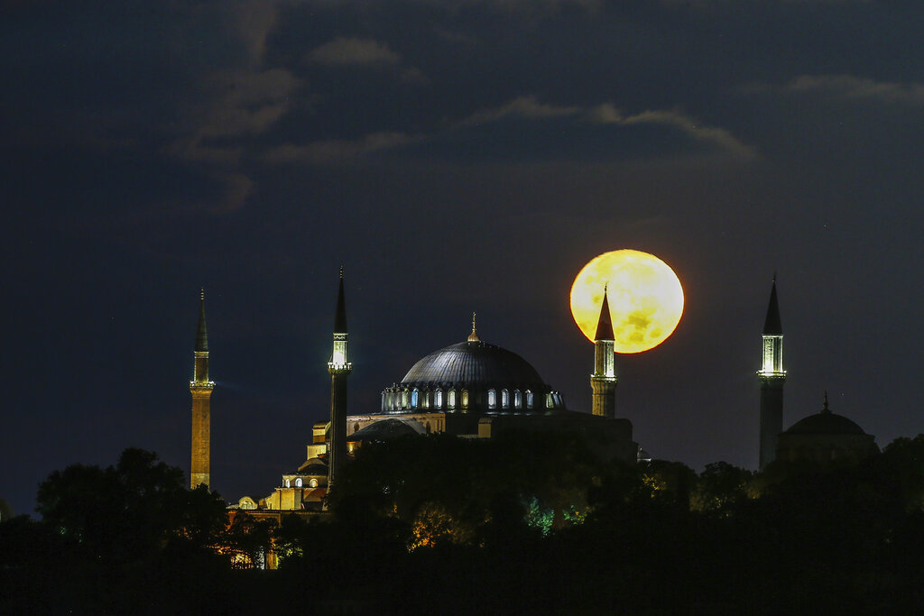 The full moon rises behind the Byzantine-era Hagia Sophia in the historic Sultanahmet district of Istanbul, early Tuesday, Sept. 1, 2020. Worshipers held the first Muslim prayers in 86 years inside the Istanbul landmark that served as one of Christendom's most significant cathedrals, a mosque and a museum before its conversion back into a Muslim place of worship on July 24, 2020. The conversion of the edifice, has led to an international outcry. (AP Photo/Emrah Gurel)