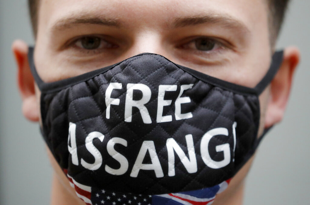 A protestor wears a face mask in front of the Central Criminal Court Old Bailey in London, Monday, Sept. 7, 2020. Lawyers for WikiLeaks founder Julian Assange and the U.S. government were squaring off in a London court on Monday at a high-stakes extradition case delayed by the coronavirus pandemic. American prosecutors have indicted the 49-year-old Australian on 18 espionage and computer misuse charges over Wikileaks’ publication of secret U.S. military documents a decade ago. The charges carry a maximum sentence of 175 years in prison. (AP Photo/Frank Augstein)