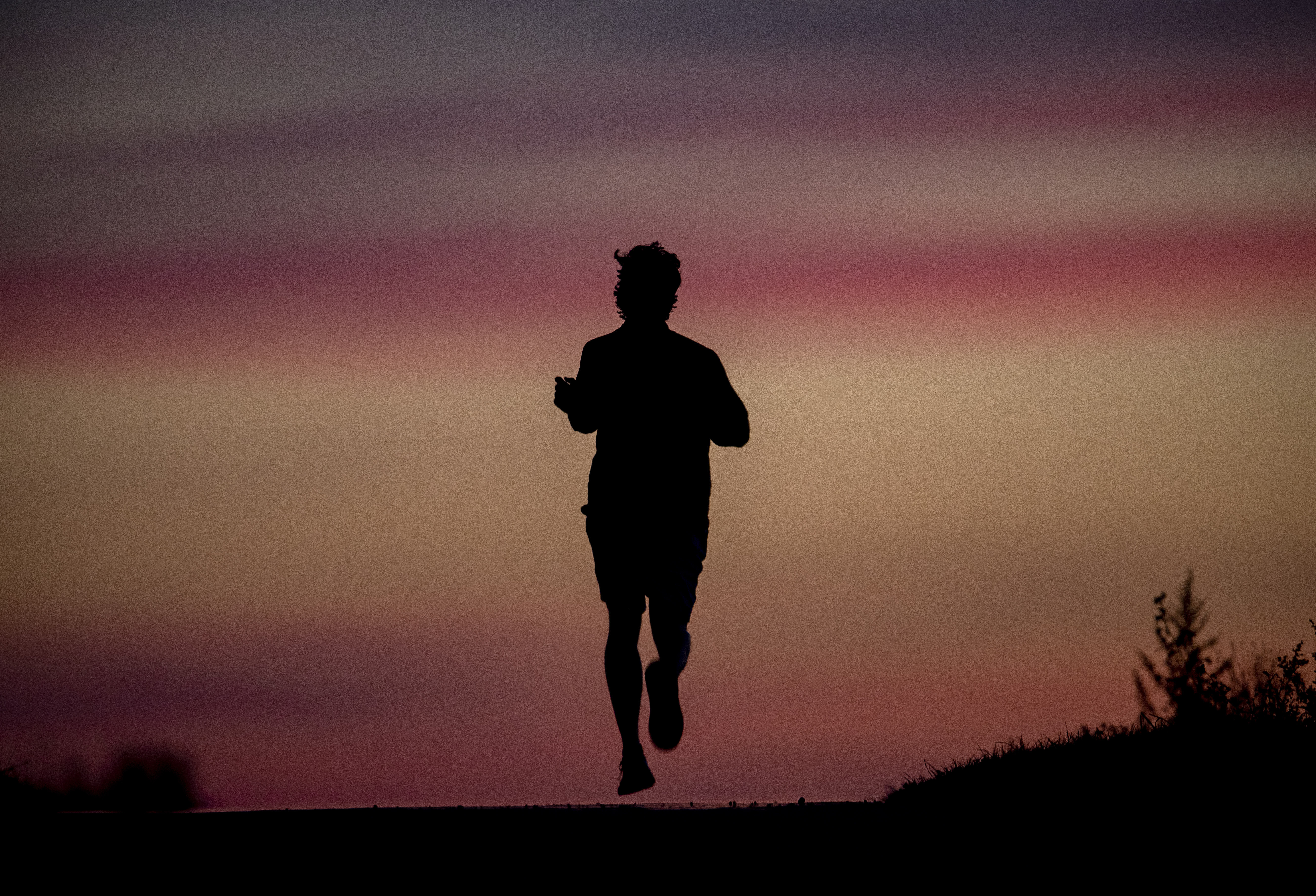 A man runs on a small road in the outskirts of Frankfurt, Germany, before sunrise on Tuesday, Sept. 8, 2020. (AP Photo/Michael Probst)