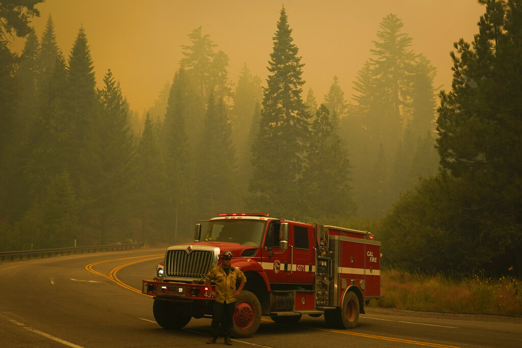 A firefighter stands in front of an engine on Highway 168 as crews monitor the advance of the Creek Fire Monday, Sept. 7, 2020, in Shaver Lake, Calif. (AP Photo/Marcio Jose Sanchez)