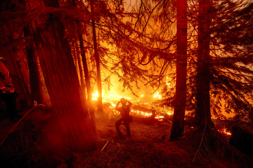 A firefighter battles the Creek Fire in the Shaver Lake community of Fresno County, Calif., on Monday, Sept. 7, 2020. (AP Photo/Noah Berger)