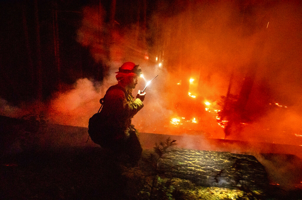 A firefighter battles the Creek Fire in the Shaver Lake community of Fresno County, Calif., on Monday, Sept. 7, 2020. (AP Photo/Noah Berger)