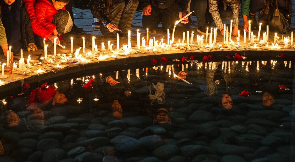 People light candles at the National Stadium during a vigil marking the anniversary of the 1973 military coup that ousted the late President Salvador Allende, in Santiago, Chile, Wednesday, Sept. 11, 2019. The stadium was used as a detention center in the early years of the dictatorship. (AP Photo/Esteban Felix)