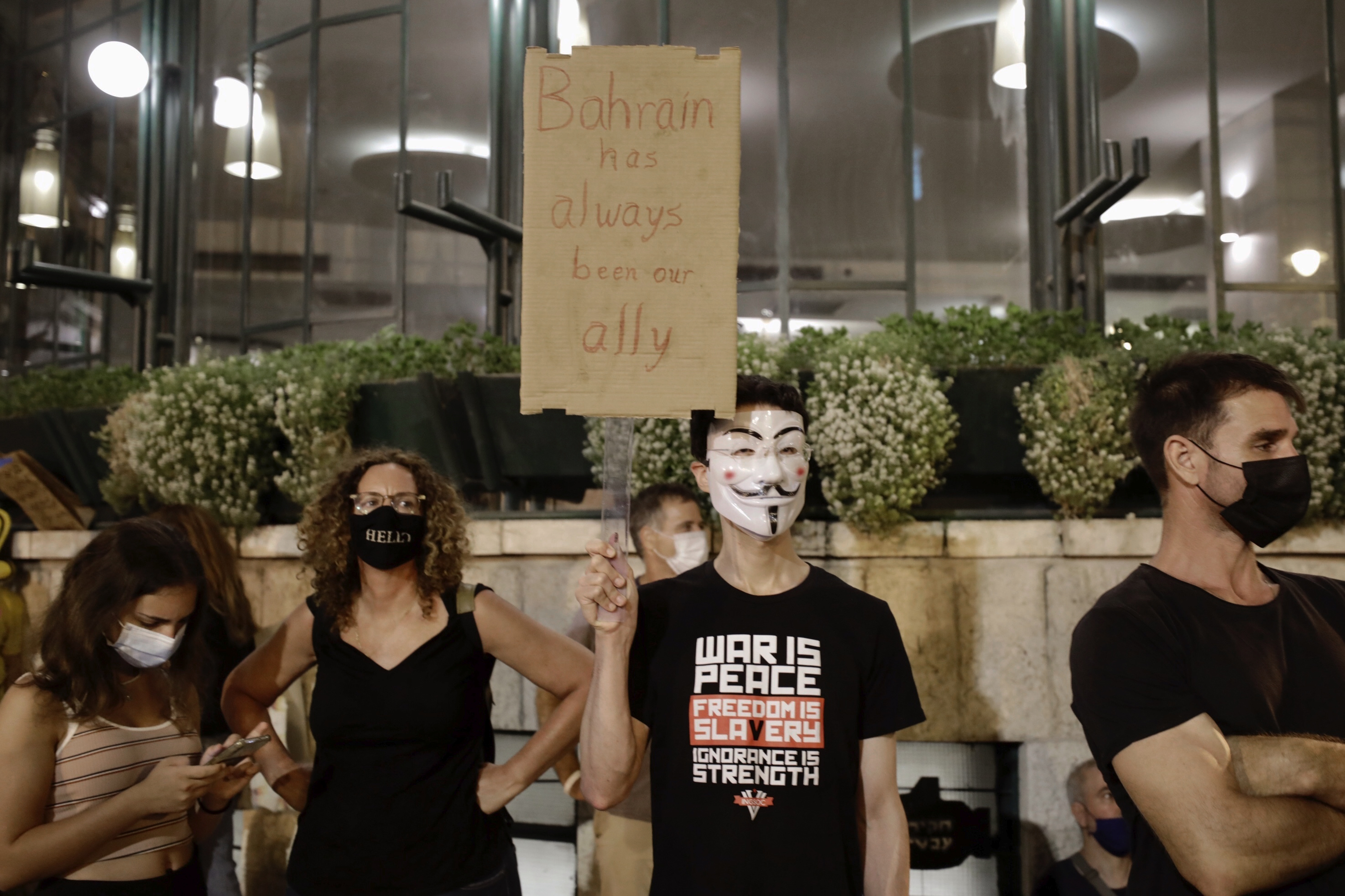 Israeli protesters hold signs during a demonstration against Israeli Prime Minister Benjamin Netanyahu outside the Prime Minister's residence in Jerusalem, Saturday, Sept. 12, 2020. (AP Photo/Sebastian Scheiner)