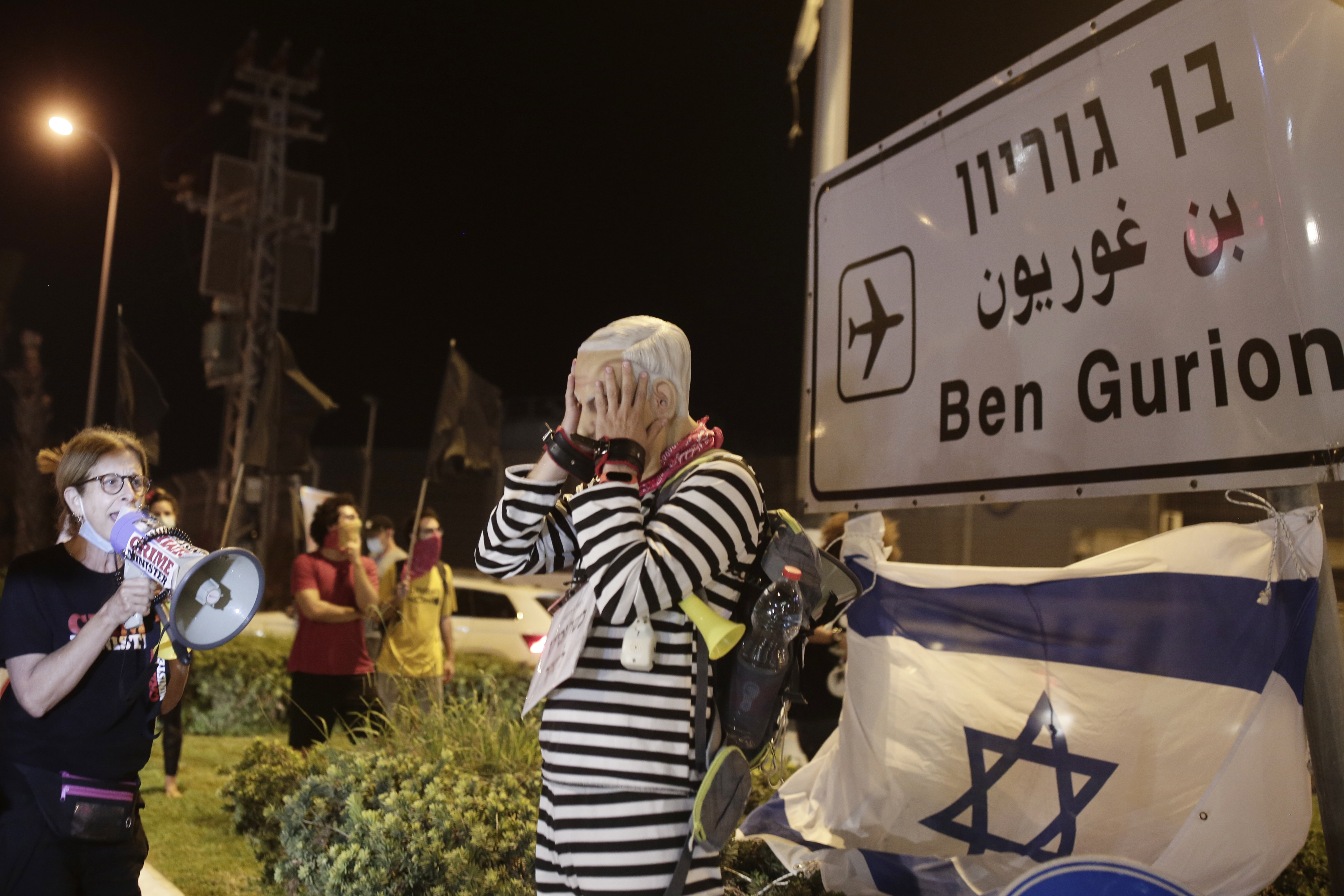 A protester wearing a rubber mask representing Israeli Prime Minister Benjamin Netanyahu stands at an entrance to Ben Gurion Airport, where Netanyahu and his family were expected to fly with an Israeli delegation to the U.S. for a ceremony with the United Arab Emirates, in Tel Aviv, Sunday, Sept. 13, 2020. (AP Photo/Maya Alleruzzo)