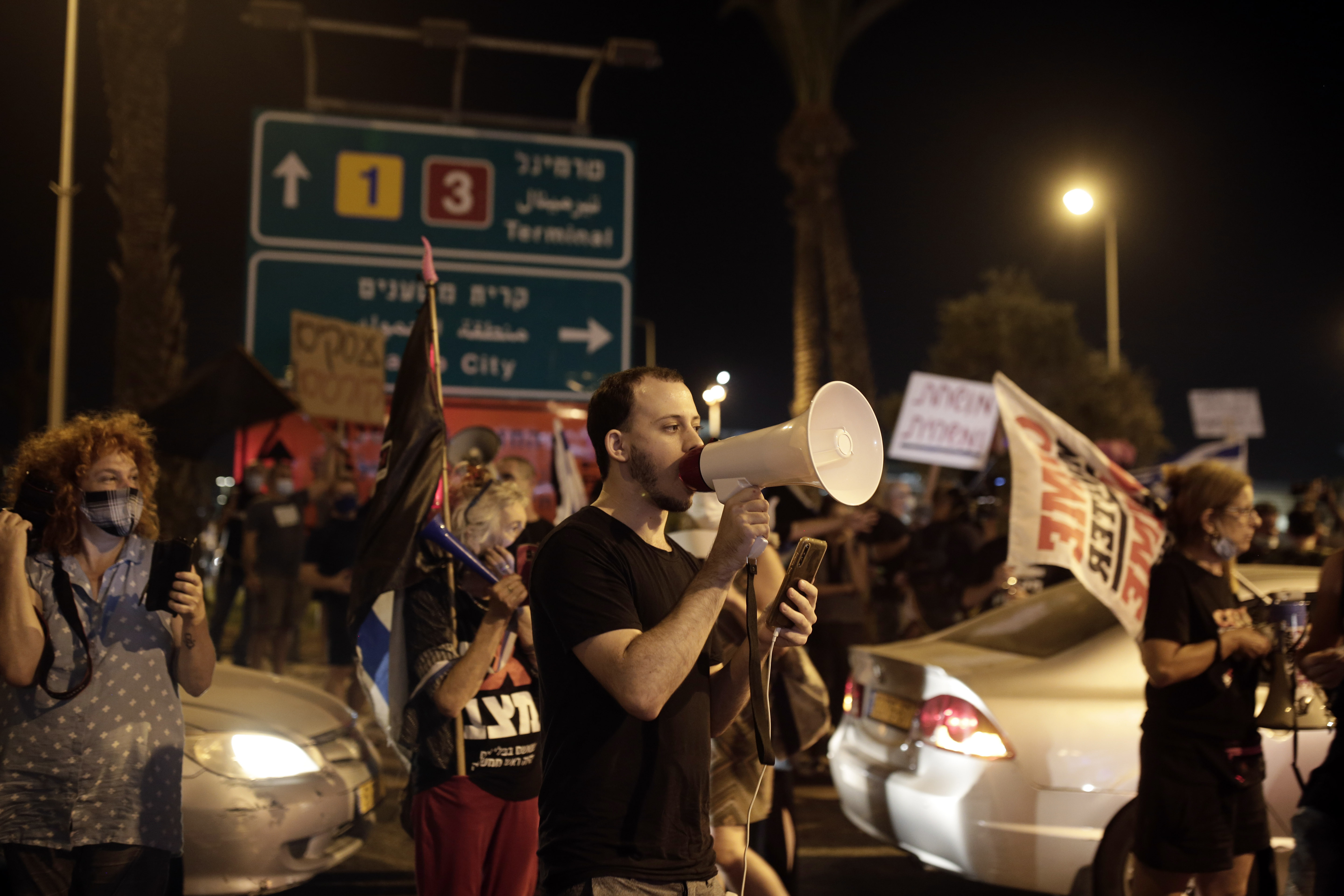 Protesters block an entrance to Ben Gurion Airport, where Israeli Prime Minister Benjamin Netanyahu and his family were expected to fly with an Israeli delegation to the U.S. for a ceremony with the United Arab Emirates, in Tel Aviv, Sunday, Sept. 13, 2020. (AP Photo/Maya Alleruzzo)