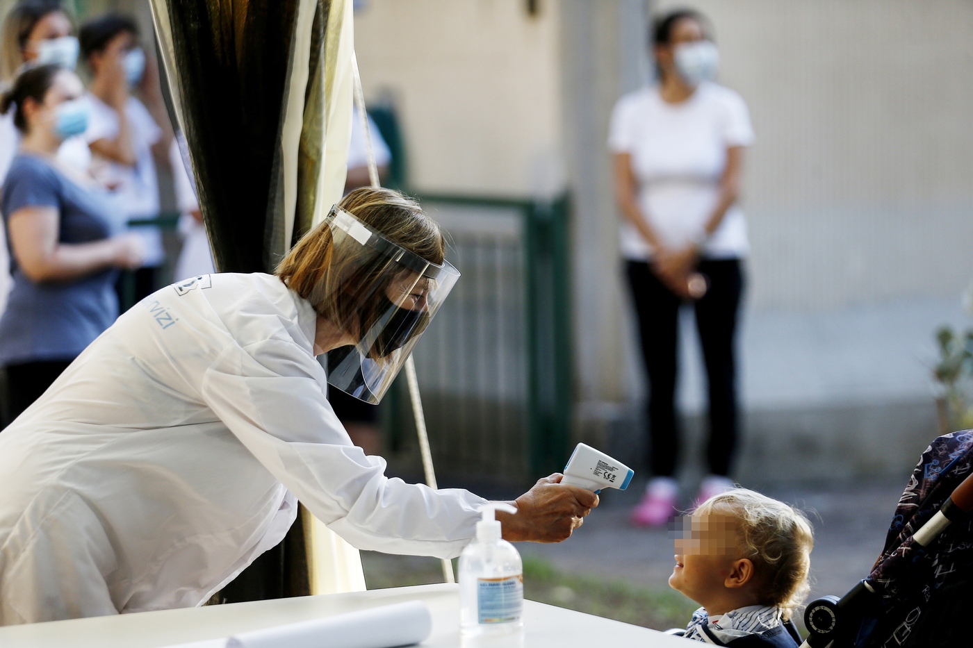 A un bambino viene misurata la temperatura all'entrata a scuola (Cecilia Fabiano/ LaPresse) 
