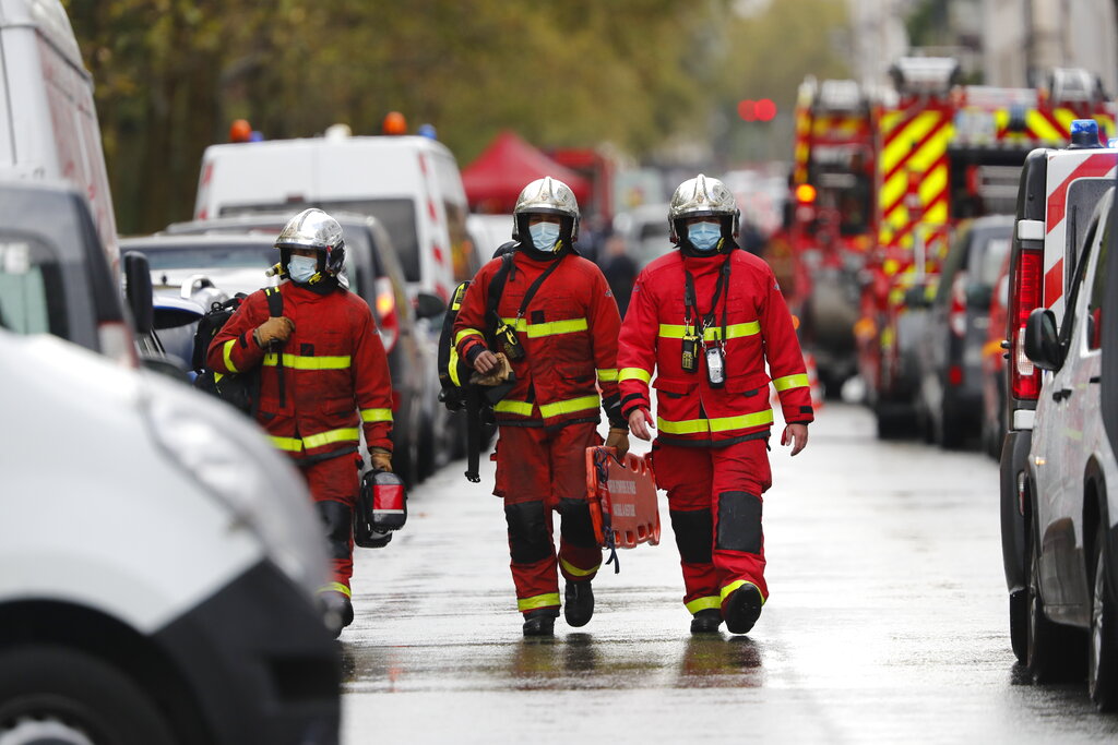 Emergency services at the scene after a knife attack near the former offices of satirical newspaper Charlie Hebdo, Friday Sept. 25, 2020 in Paris. Paris police say they have arrested a man suspected of a knife attack that wounded at least two people near the former offices of satirical newspaper Charlie Hebdo. Police initially thought there were two attackers but now say there was only one.  (AP Photo/Thibault Camus)