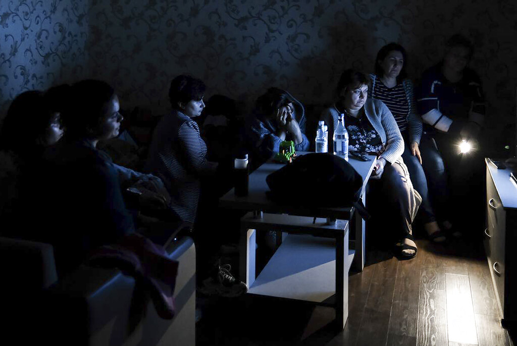 In this handout photo released by the Armenian Foreign Ministry on Monday, Sept. 28, 2020, people watch the State TV as they gather in a bomb shelter to protect against the shelling in Stepanakert, the self-proclaimed Republic of Nagorno-Karabakh, Azerbaijan. Nagorno-Karabakh authorities reported that shelling hit the region's capital of Stepanakert and the towns of Martakert and Martuni. Armenian Defense Ministry spokesman Artsrun Hovhannisyan also said Azerbaijani shelling hit within Armenian territory near the town of Vardenis. (Armenian Foreign Ministry via AP)