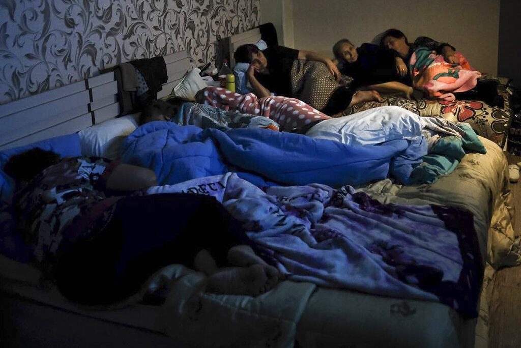 In this handout photo released by the Armenian Foreign Ministry on Monday, Sept. 28, 2020, people watch the State TV as they gather in a bomb shelter to protect against the shelling in Stepanakert, the self-proclaimed Republic of Nagorno-Karabakh, Azerbaijan. Nagorno-Karabakh authorities reported that shelling hit the region's capital of Stepanakert and the towns of Martakert and Martuni. Armenian Defense Ministry spokesman Artsrun Hovhannisyan also said Azerbaijani shelling hit within Armenian territory near the town of Vardenis. (Armenian Foreign Ministry via AP)