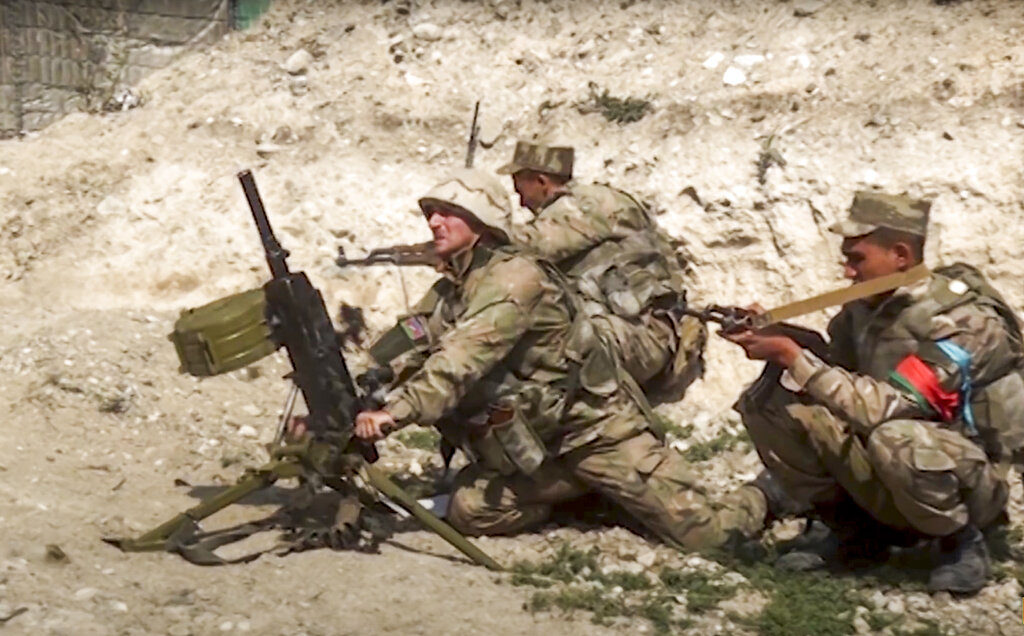 In this image taken from footage released by Azerbaijan's Defense Ministry on Sunday, Sept. 27, 2020, Azerbaijan's soldiers fire from a mortar at the contact line of the self-proclaimed Republic of Nagorno-Karabakh, Azerbaijan. Fighting between Armenian and Azerbaijani forces over the disputed separatist region of Nagorno-Karabakh continued on Monday morning after erupting the day before, with both sides blaming each other for resuming the attacks. (Azerbaijan's Defense Ministry via AP)