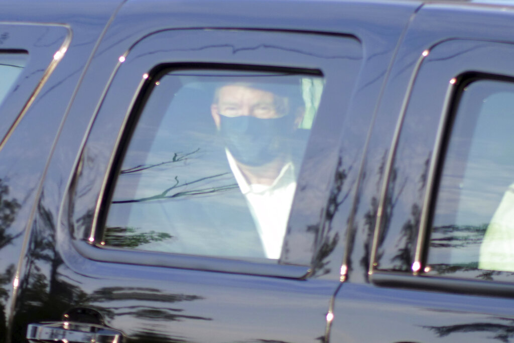 President Donald Trump drives past supporters gathered outside Walter Reed National Military Medical Center in Bethesda, Md., Sunday, Oct. 4, 2020. Trump was admitted to the hospital after contracting COVID-19. (AP Photo/Anthony Peltier)