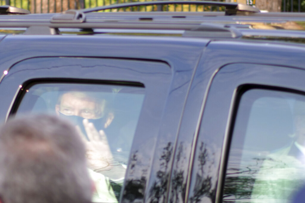 President Donald Trump drives past supporters gathered outside Walter Reed National Military Medical Center in Bethesda, Md., Sunday, Oct. 4, 2020. Trump was admitted to the hospital after contracting COVID-19. (AP Photo/Anthony Peltier)