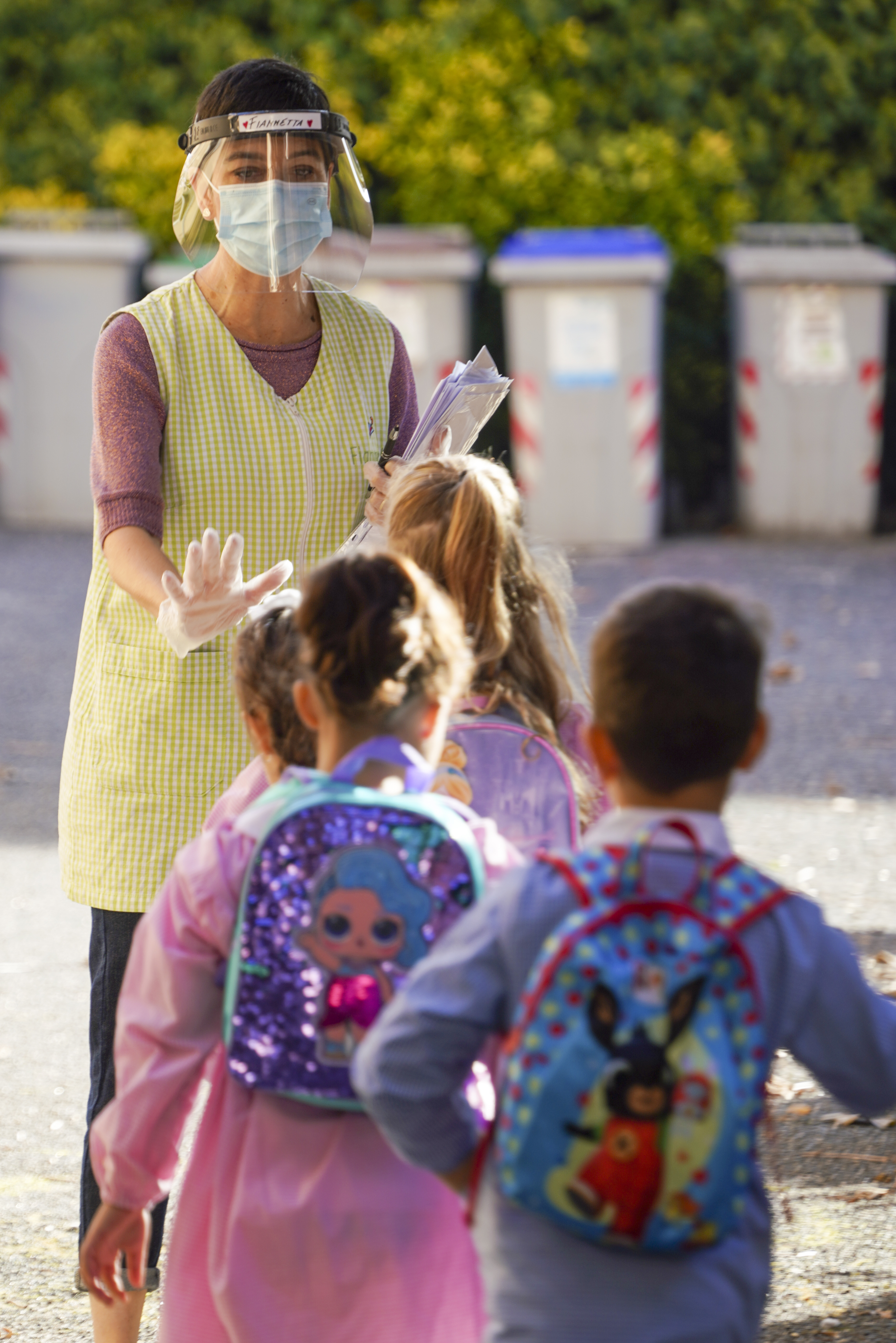 Medical personnel accompanies children to receive non-invasive Covid-19 tests with chewing gum, at the G.B. Grassi school, in Fiumicino, near Rome, Tuesday, Oct. 6, 2020. (AP Photo/Andrew Medichini)