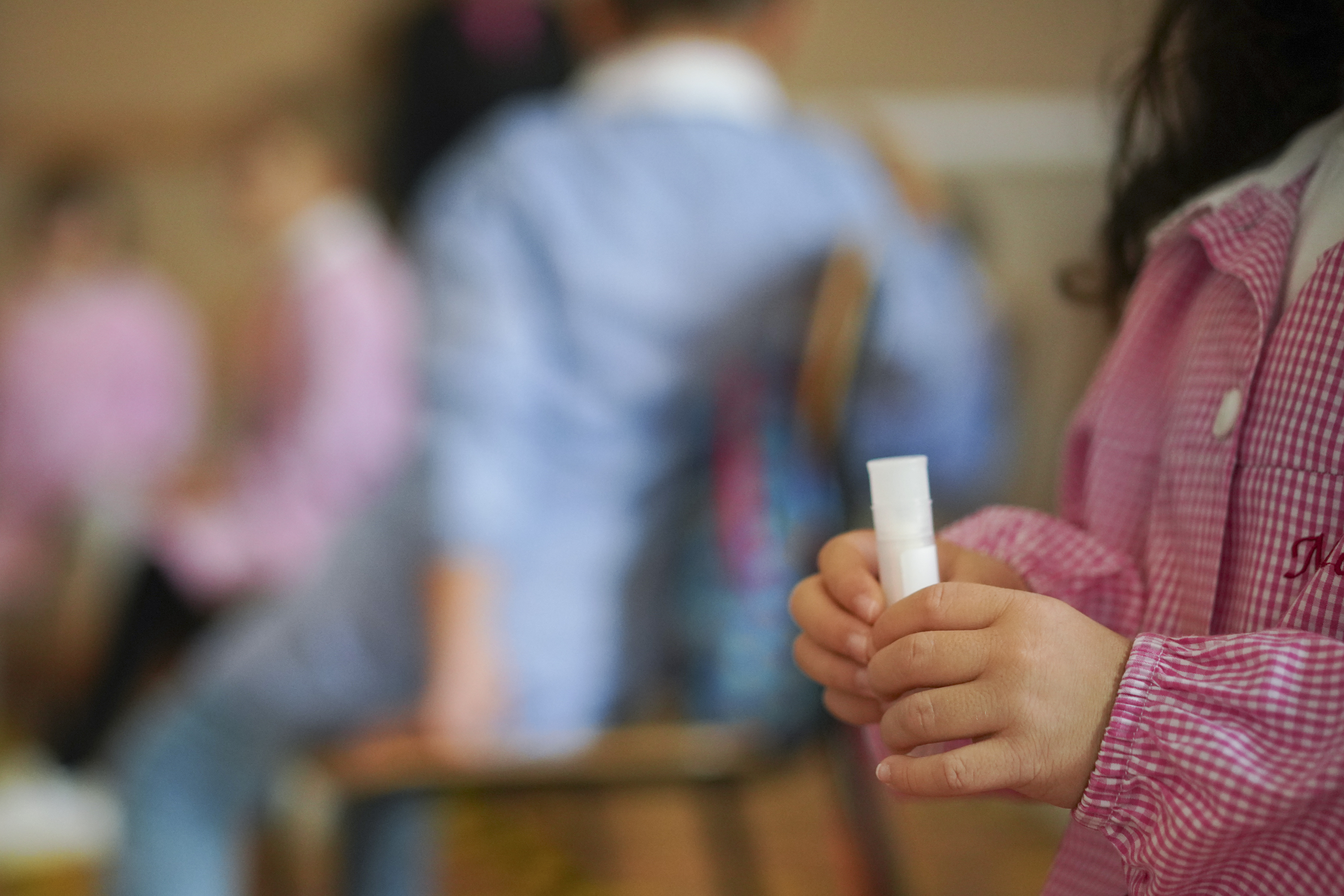 A child holds a non-invasive Covid 19 test with chewing gum which was handed to her by medical personnel at the G.B. Grassi school, in Fiumicino, near Rome, Tuesday, Oct. 6, 2020. (AP Photo/Andrew Medichini)