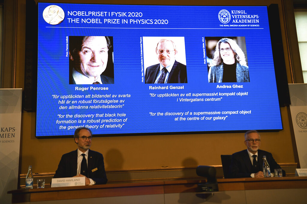 David Haviland, member of the Nobel Committee for Physics, left, and Goran K. Hansson, Secretary General of the Academy of Sciences, announce the winners of the 2020 Nobel Prize in Physics during a news conference at the Royal Swedish Academy of Sciences, in Stockholm, Sweden, Tuesday Oct. 6, 2020. The three winners on the screen from left, Roger Penrose, Reinhard Genzel and Andrea Ghez have won this year’s Nobel Prize in physics for black hole discoveries. (Fredrik Sandberg/TT via AP)