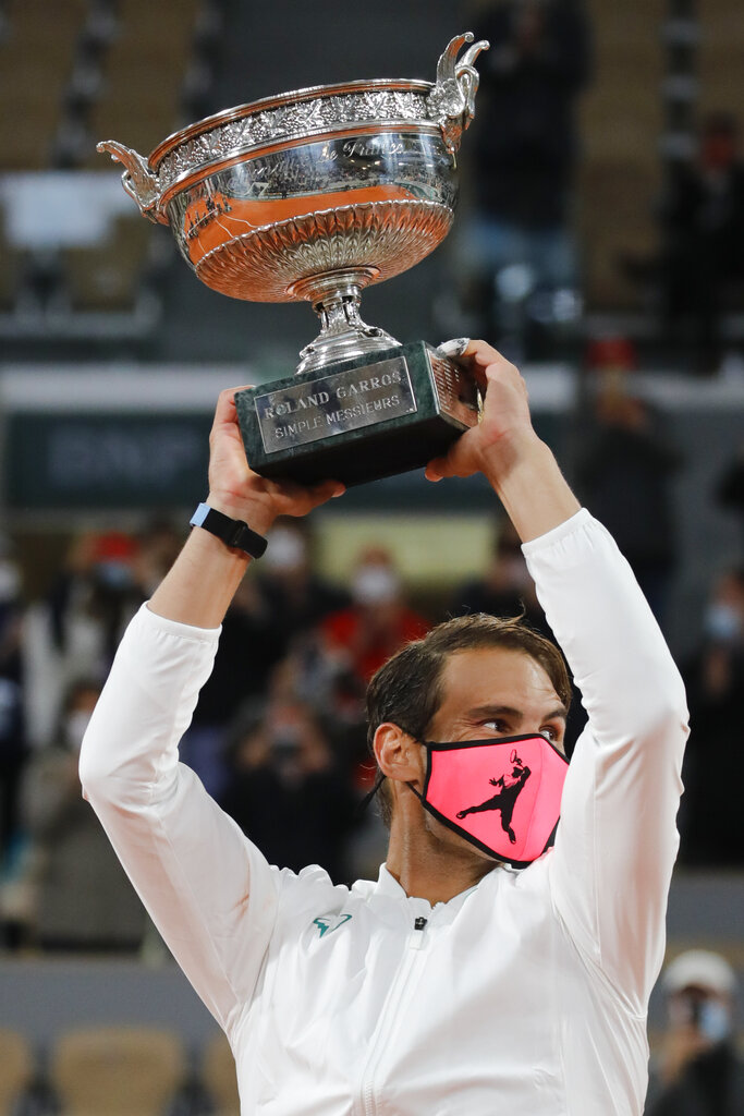 Spain's Rafael Nadal holds the trophy as he celebrates winning the final match of the French Open tennis tournament against Serbia's Novak Djokovic in three sets, 6-0, 6-2, 7-5, at the Roland Garros stadium in Paris, France, Sunday, Oct. 11, 2020. (AP Photo/Christophe Ena)