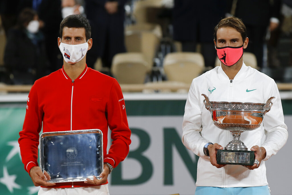 Spain's Rafael Nadal holds the trophy, right, as he celebrates winning the final match of the French Open tennis tournament against Serbia's Novak Djokovic, left, in three sets, 6-0, 6-2, 7-5, at the Roland Garros stadium in Paris, France, Sunday, Oct. 11, 2020. (AP Photo/Michel Euler)