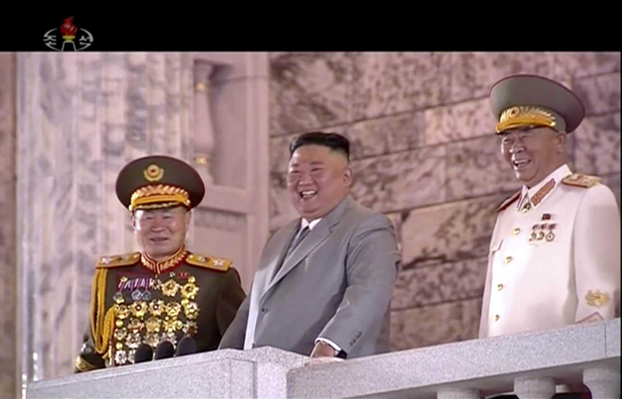 In this image made from video broadcasted by North Korea's KRT, North Korean leader Kim Jong Un, center, watches military parade during a ceremony to celebrate the 75th anniversary of the country’s ruling party in Pyongyang Saturday, Oct. 10, 2020. Kim warned Saturday that his country would “fully mobilize” its nuclear force if threatened as he took center stage at the massive military parade.(KRT via AP)