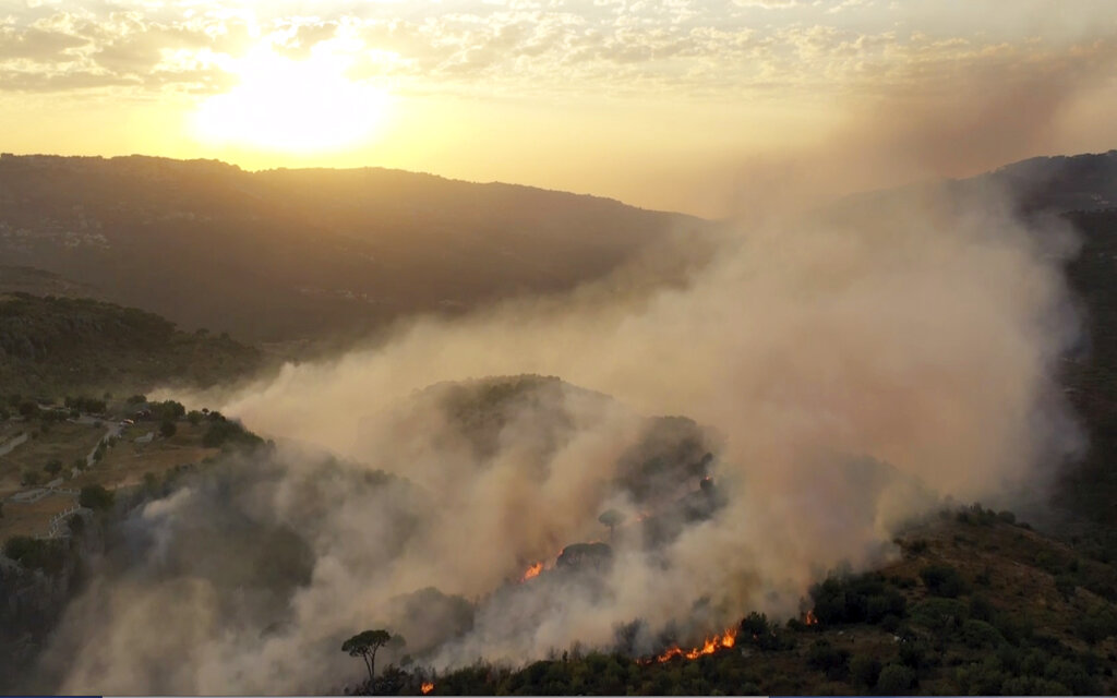 In this frame grab from video, flames rise at the scene of forest fire in Ras el-Harf village, in the Baabda district, Lebanon, Friday, Oct. 9, 2020. Wildfires around the Middle East triggered by a heatwave hitting the region have killed two people, forced thousands of people to leave their homes and detonated landmines along the Lebanon-Israel border, state media and officials said Saturday. (AP Photo)