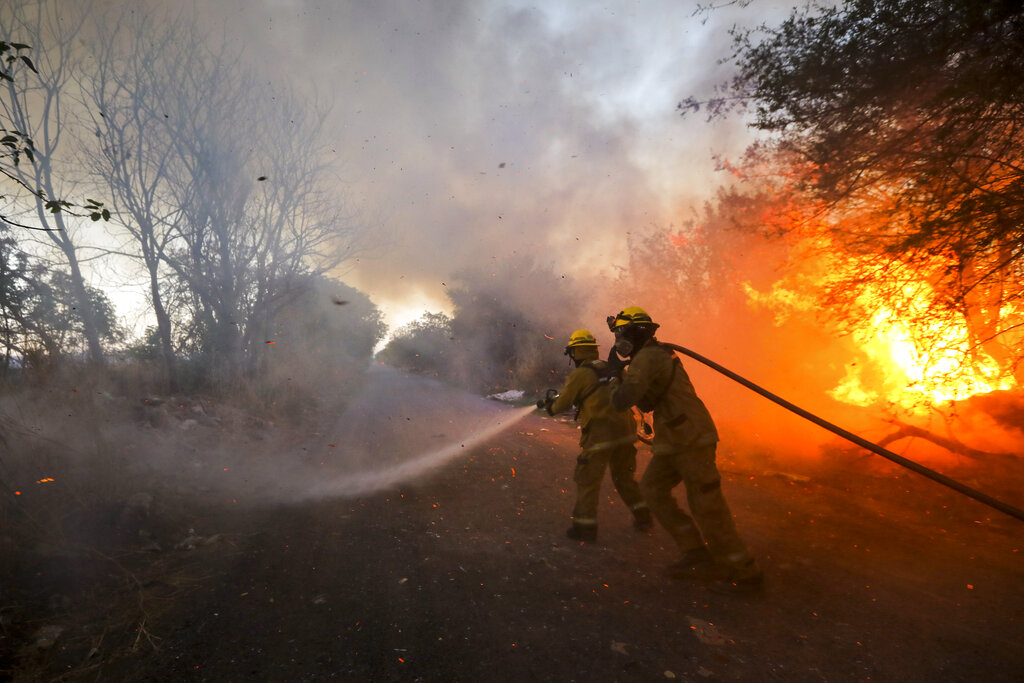 Firefighters battle the flames in Cordoba, Argentina, Monday, Oct. 12, 2020. The Cordoba province has reported nearly 50,000 hectares in fires since the beginning of the year amid high temperatures and strong winds. (AP Photo/Nicolas Aguilera)(AP Photo/Nicolas Aguilera)