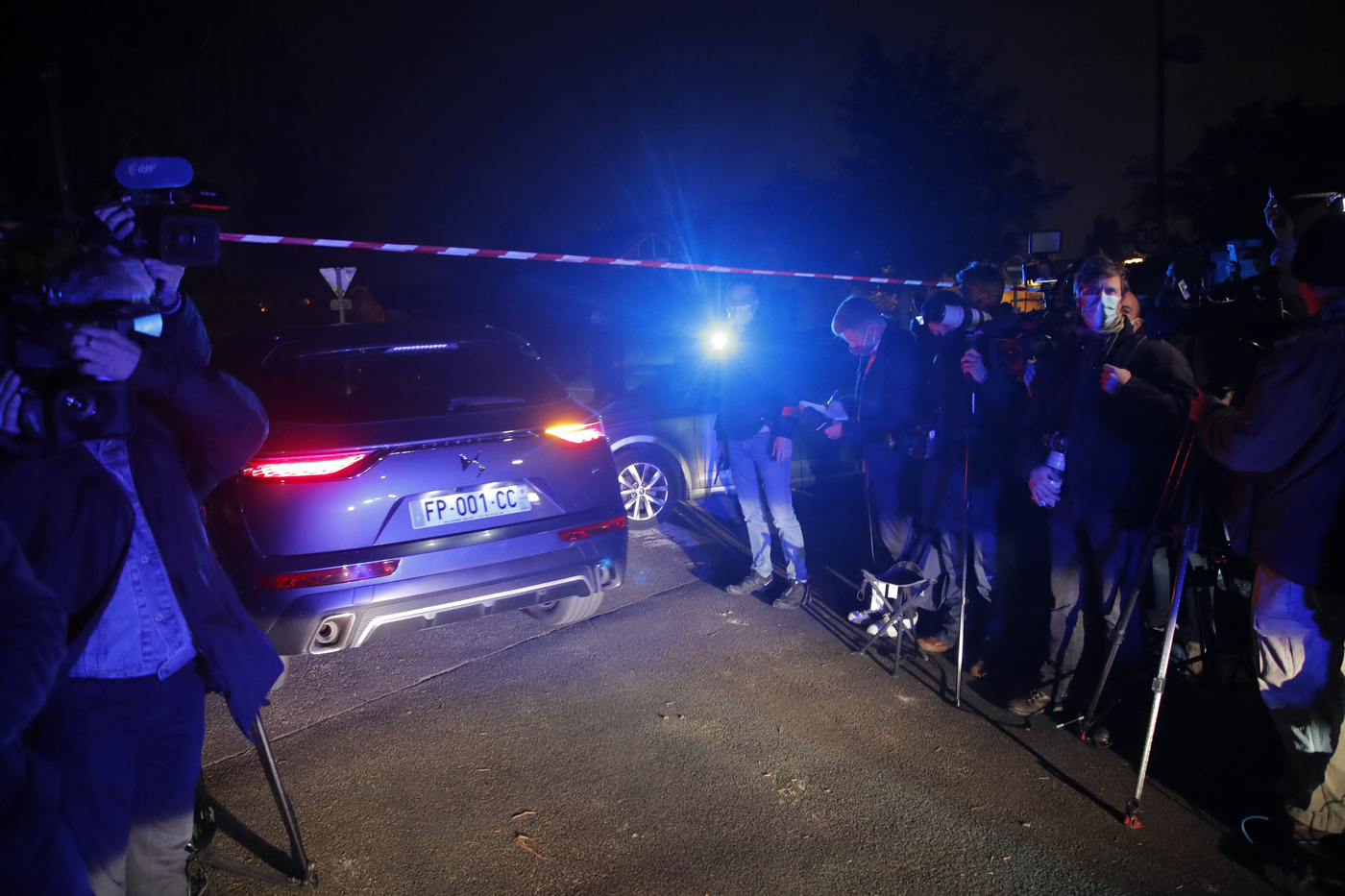 A police car enters the perimeter after a history teacher who opened a discussion with students on caricatures of Islam's Prophet Muhammad was decapitated, Friday, Oct. 16, 2020 in Conflans-Saint-Honorine, north of Paris. Police have shot the suspected killer dead. (AP Photo/Michel Euler)