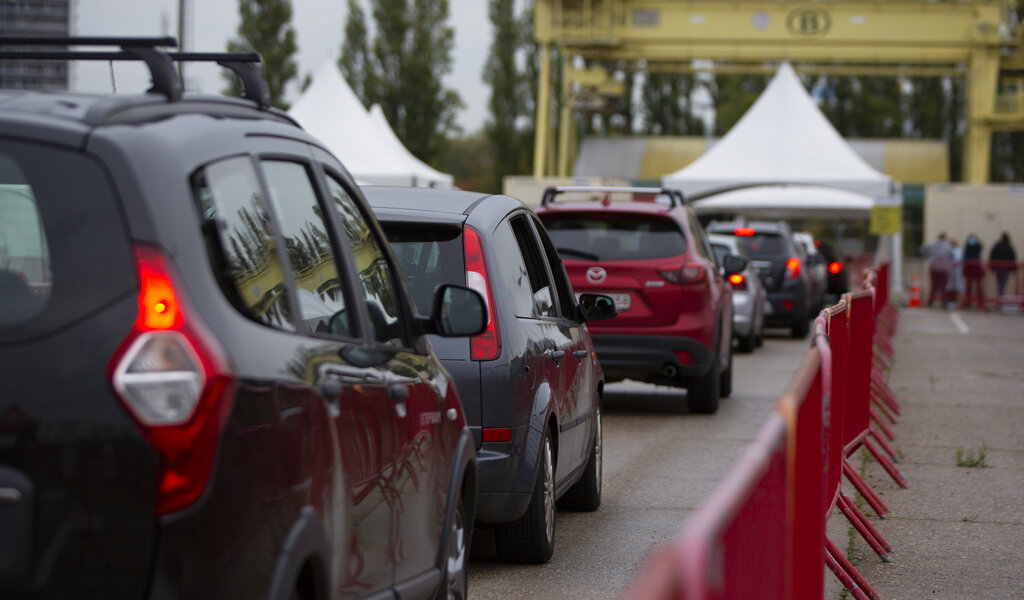 People wait in their cars in a line to be tested at the mobile COVID-19 testing site in Antwerp, Belgium, Tuesday, Oct. 20, 2020. Bars and restaurants across Belgium have been shut down for a month and a night-time curfew entered into force Monday, as health authorities warned of a possible sanitary 