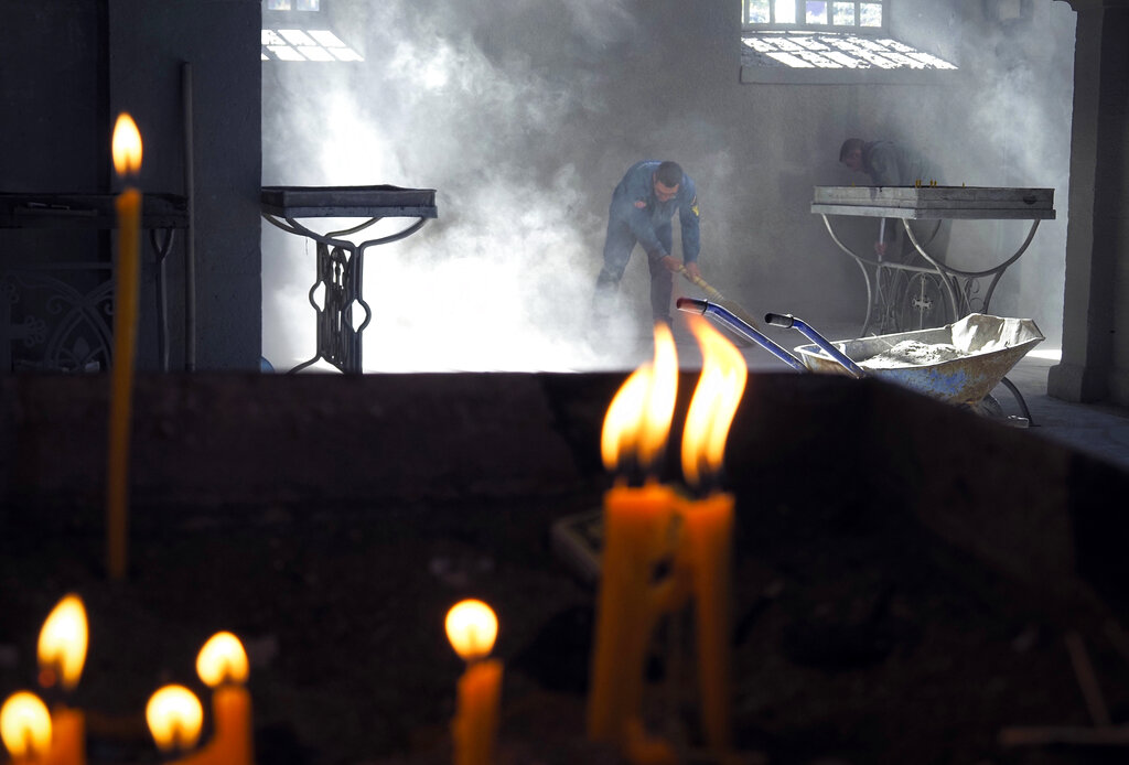 Church workers sweep the dust in the Holy Savior Cathedral, damaged by shelling by Azerbaijan's artillery during a military conflict in Shushi, the separatist region of Nagorno-Karabakh, Saturday, Oct. 24, 2020. The heavy shelling forced residents of Stepanakert, the regional capital of Nagorno-Karabakh, into shelters, as emergency teams rushed to extinguish fires. Nagorno-Karabakh authorities said other towns in the region were also targeted by Azerbaijani artillery fire. (AP Photo)