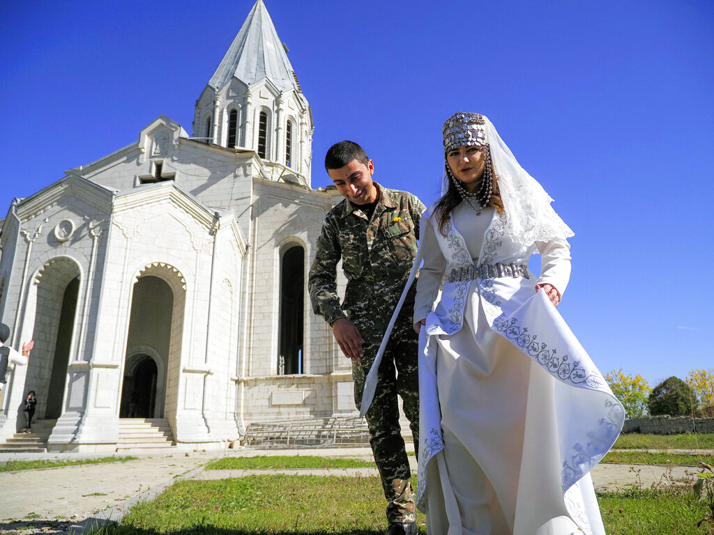 Newlyweds, soldier Hovhannes Hovsepyan, left, and Mariam Sargsyan walk after their wedding ceremony in the Holy Savior Cathedral, damaged by shelling by Azerbaijan's artillery during a military conflict in Shushi, the separatist region of Nagorno-Karabakh, Saturday, Oct. 24, 2020. The wedding was celebrated even as intense fighting in the region has continued. (AP Photo)