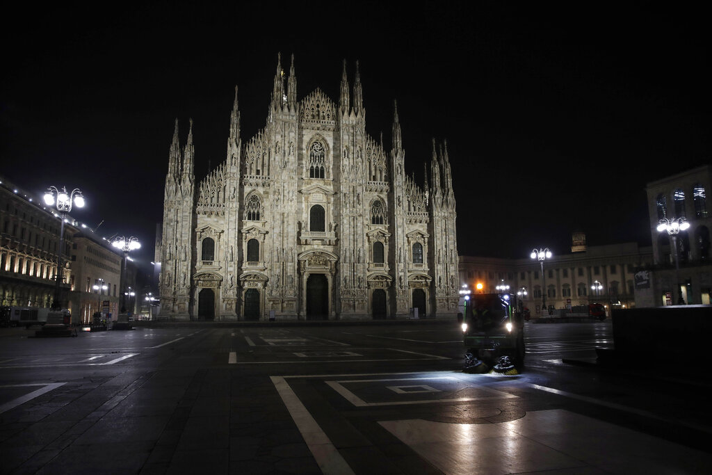 A street cleaning vehicle washes the square in front of the Duomo gothic cathedral, in Milan, northern Italy, early Sunday, Oct. 25, 2020. Since the 11 p.m.-5 a.m. curfew took effect last Thursday, people can only move around during those hours for reasons of work, health or necessity. (AP Photo/Luca Bruno)