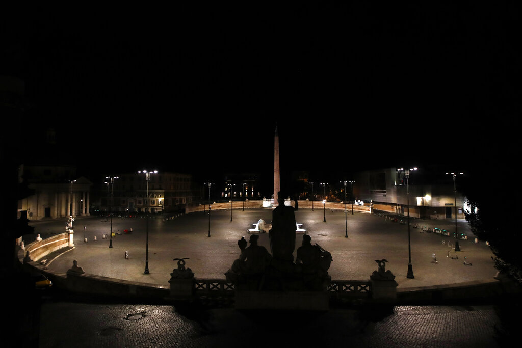 An empty Piazza del Popolo Square is seen in Rome, early Monday, Oct. 26, 2020. Since an 11 p.m.-5 a.m. curfew took effect Friday, people can only move around during those hours for reasons of work, health or necessity. (AP Photo/Alessandra Tarantino)