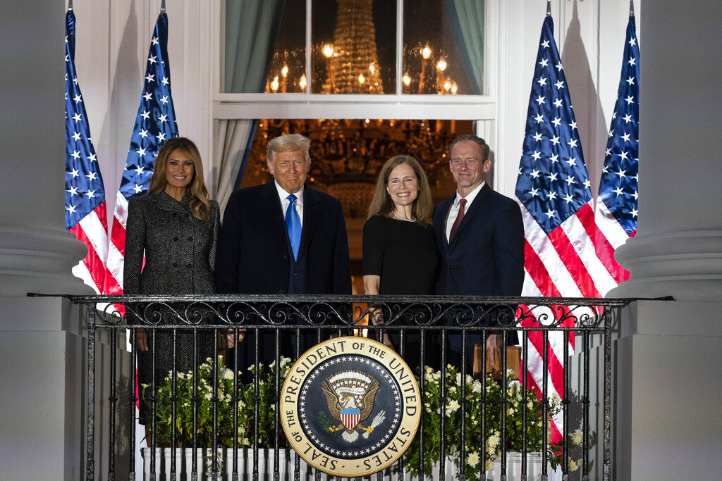 President Donald Trump, first lady Melania Trump, and Amy Coney Barrett and her husband Jesse stand on the Blue Room Balcony after Supreme Court Justice Clarence Thomas administered the Constitutional Oath to her on the South Lawn of the White House White House in Washington, Monday, Oct. 26, 2020. Barrett was confirmed to be a Supreme Court justice by the Senate earlier in the evening. (AP Photo/Alex Brandon)