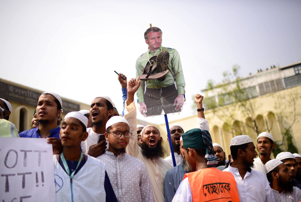 Supporters of Islami Andolan Bangladesh, an Islamist political party, carry a cutout of French President Emmanuel Macron with a garland of footwear around it as they protest against the publishing of caricatures of the Prophet Muhammad they deem blasphemous, in Dhaka, Bangladesh, Tuesday, Oct. 27, 2020. Muslims in the Middle East and beyond on Monday called for boycotts of French products and for protests over the caricatures, but Macron has vowed his country will not back down from its secular ideals and defense of free speech. (AP Photo/Mahmud Hossain Opu)