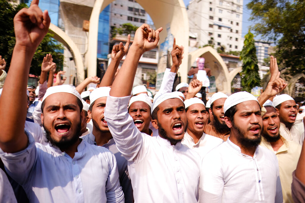 Supporters of Islami Oikya Jote, an Islamist political party, protest against French President Emmanuel Macron and against the publishing of caricatures of the Prophet Muhammad they deem blasphemous, in Dhaka, Bangladesh, Wednesday, Oct. 28, 2020. Muslims in the Middle East and beyond on Monday called for boycotts of French products and for protests over the caricatures, but Macron has vowed his country will not back down from its secular ideals and defense of free speech. Posters read 