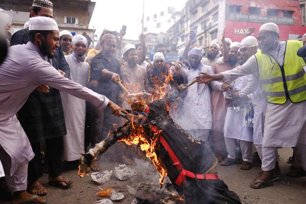 Bangladeshi Muslims protesting the French president’s support of secular laws allowing caricatures of the Prophet Muhammad march burn an effigy of French President Emmanuel Macron in Dhaka, Bangladesh, Monday, Nov.2, 2020. (AP Photo/Mahmud Hossain Opu)