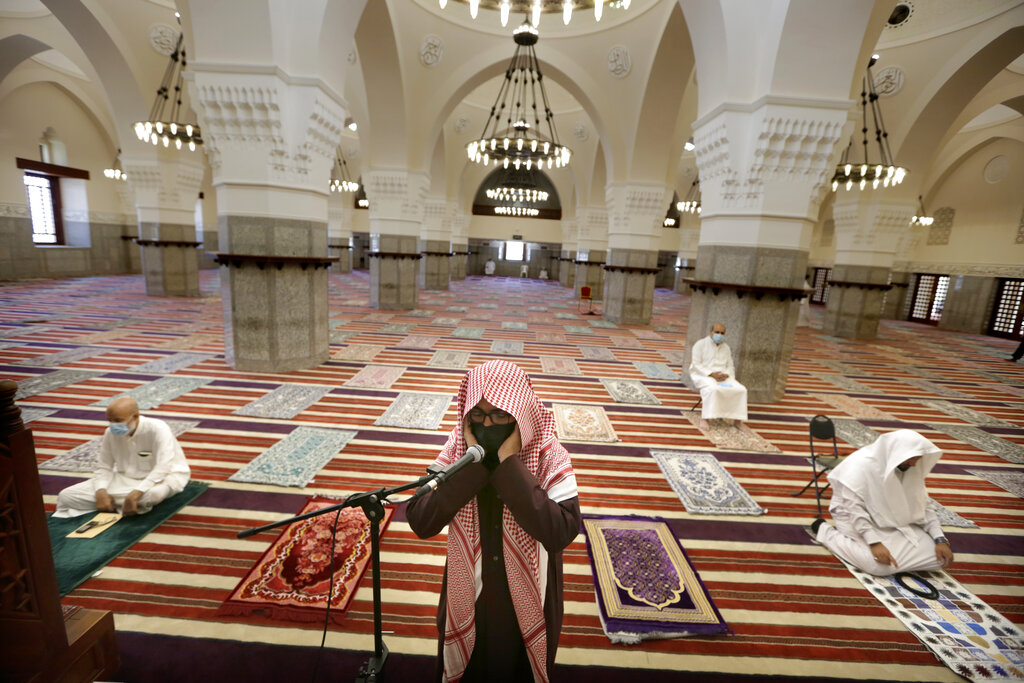 Saudi cleric Mohammed Al Hajj recites the call to prayers as worshippers wearing face masks and observing social distancing guidelines to protect against the new coronavirus, attend prayers at Al- Jaffali mosque ahead of Friday prayer during the Muslim fasting month of Ramadan, in Jiddah, Saudi Arabia, Friday, April 30, 2021. (AP Photo/Amr Nabil)