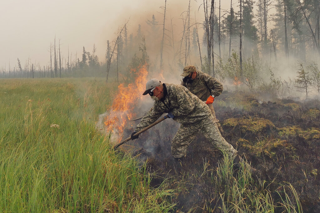 Volunteers douse a forest fire in the republic of Sakha also known as Yakutia, Russia Far East, Saturday, July 17, 2021. Russia has been plagued by widespread forest fires, blamed on unusually high temperatures and the neglect of fire safety rules, with the Sakha-Yakutia region in northeastern Siberia being the worst affected. (AP Photo/Ivan Nikiforov)