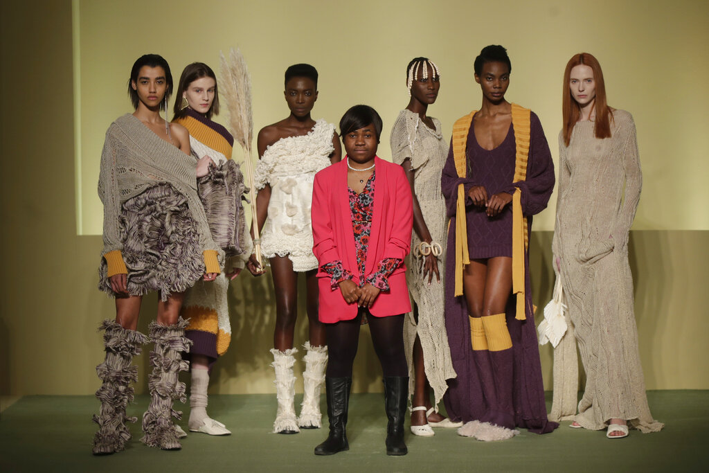 Fashion designer Gisele Claudia Ntsama poses with models during the Black Lives Matter Fall/Winter 2021/22 collection collective show, presented in Milan, Italy, Wednesday, Feb. 17, 2021. 2021. Five Italian designers of African origin made their runway debut during Milan Fashion Week on Wednesday, Feb. 24, 2021 under the banner “We are Made in Italy,” having nurtured dreams deemed unlikely in their native lands and which faced considerable obstacles in their adopted Italy.  (AP Photo/Luca Bruno)