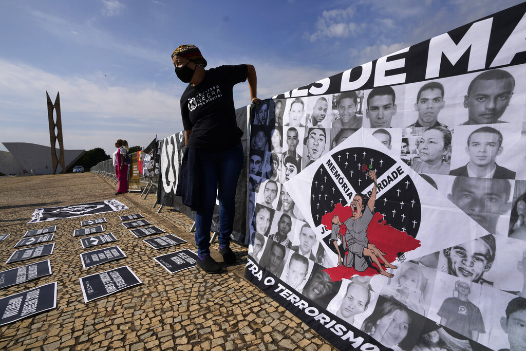 Photos of people of color who activists say were killed by police are displayed at a protest to demand justice outside the Supreme Court in Brasilia, Brazil, Thursday, May 12, 2022, the eve of the anniversary of the abolition of slavery. Brazil abolished slavery on May 13, 1888 in Brazil. (AP Photo/Eraldo Peres)