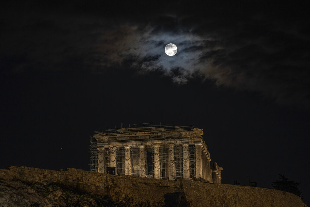 The last full moon of the year known as the cold moon rises above the ancient Parthenon temple during a cloudy day, in Athens, Wednesday, Dec. 7, 2022.(AP Photo/Petros Giannakouris)