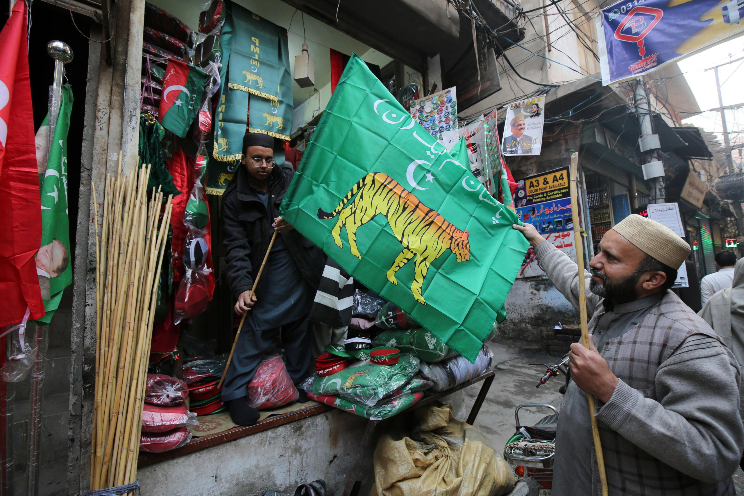 epa11067350 Vendors sell party flags as the country gears up for general elections, in Peshawar, Pakistan, 10 January 2024. General elections are set to be held in Pakistan on 08 February 2024.  EPA/BILAWAL ARBAB